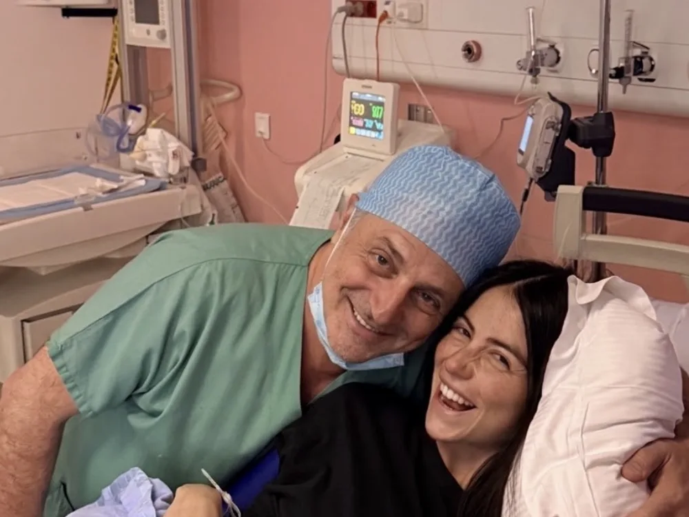 Le Dr Olivier Kadoch auprès d'une patiente après une naissance, en maternité